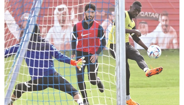 Qataru2019s forward Almoez Ali (right) shoots on goal during a training session with teammates in Vienna yesterday, on the eve of their friendly match against Chile.