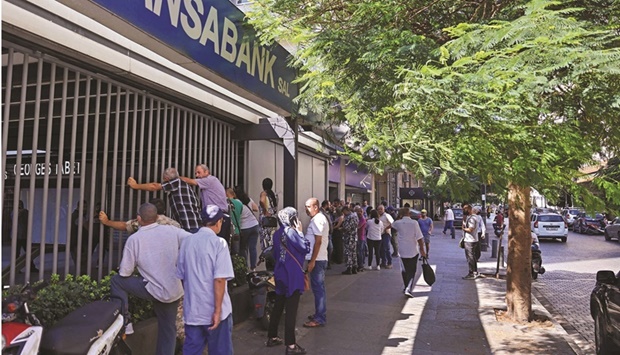 Lebanese depositors queue to withdraw money from a Fransabank branch in Beirut yesterday, as banks partially re-opened following a week of closure due to security concerns.