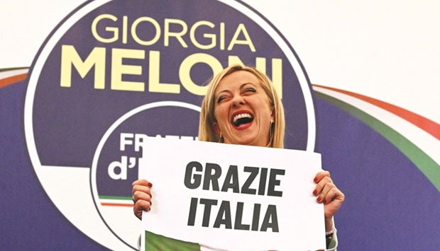 Leader of Italian far-right party u201cFratelli du2019Italiau201d (Brothers of Italy), Giorgia Meloni reacts as she holds a placard reading u201cThank You Italyu201d after she delivered an address at her partyu2019s campaign headquarters overnight yesterday in Rome.  (AFP)
