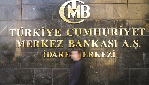 A man leaves Turkiyeu2019s central bank headquarters in Ankara (file). The bank cut its policy rate by 200 basis points to 12% in the last two months after inflation surged to 80% in August.