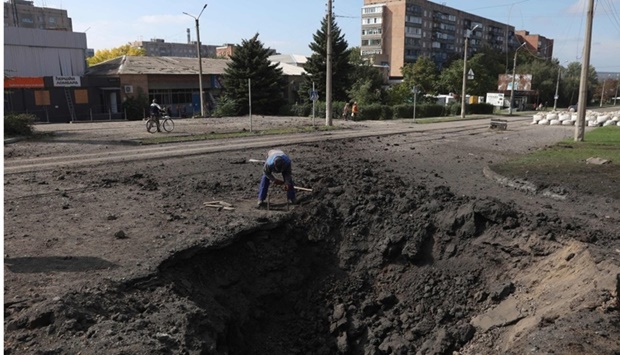 A communal service worker fixes damages after a missile strike in Kramatorsk, Donetsk region on September 29, amid the Russian invasion of Ukraine. AFP