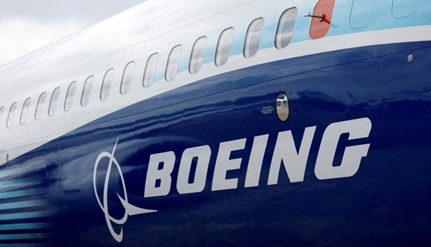 The Boeing logo is seen on the side of a Boeing 737 MAX at the Farnborough International Airshow, in Farnborough, Britain, July 20, 2022. REUTERS/Peter Cziborra/File Photo