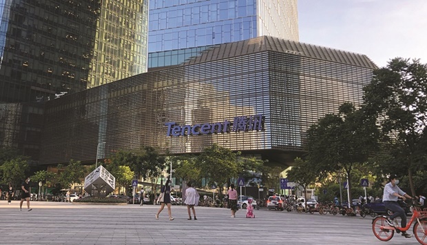 People are seen in front of the Tencent company headquarters in Shenzhen. Investors are fretting that Tencent will add to pressure on the market if it moves ahead with a reported plan to offload $14.5bn from its equity portfolio.
