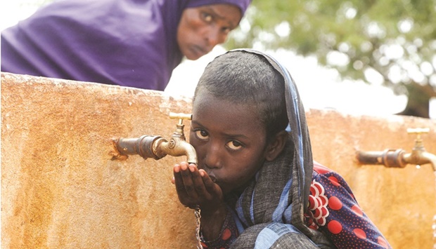 File photo shows a Somali displaced girl Sadia Ali, 8, drinking water from a tap at the Kaxareey camp for the internally displaced people in Dollow, Gedo region of Somalia.