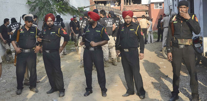 Security personnel stand at the site of a gunfight in Dinanagar town in Gurdaspur.