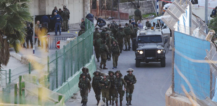 Israeli security forces gather at the site where a Palestinian was shot dead in Hebron yesterday.
