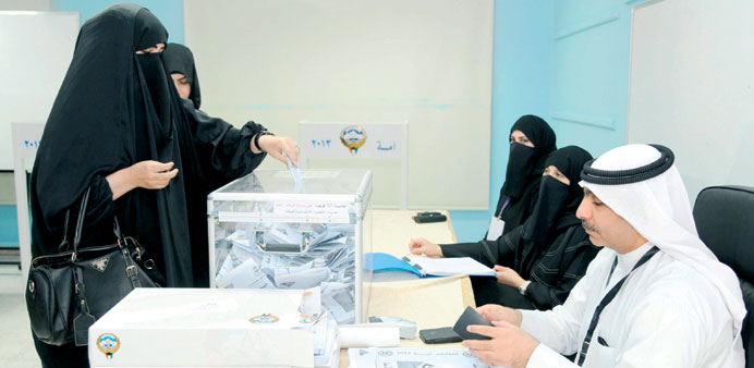  A woman casts her ballot at a polling station in Kuwait City yesterday.