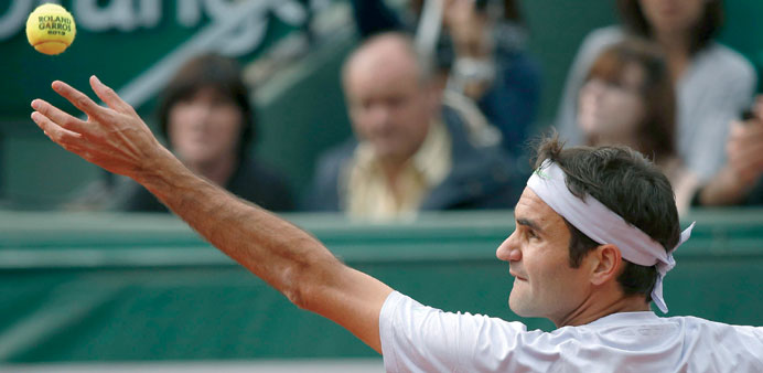 Switzerlandu2019s Roger Federer serves to Indiau2019s Somdev Devvarman during their French Open match at the Roland Garros stadium in Paris.  (AFP)