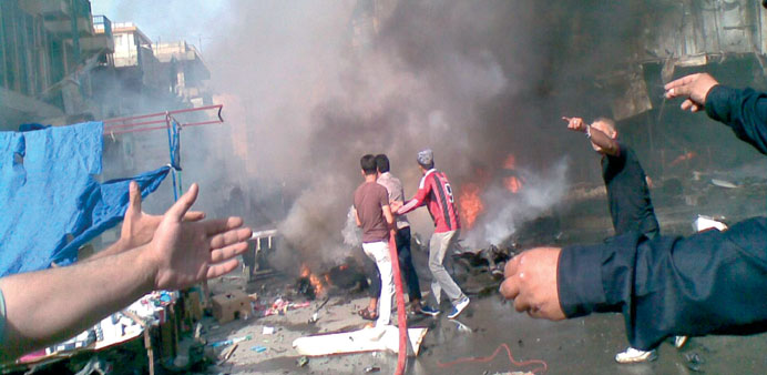 People gather at the site of a car bomb attack in Baghdad yesterday.