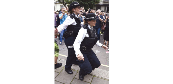 Police officers dance in the street at the Notting Hill Carnival in west London yesterday.