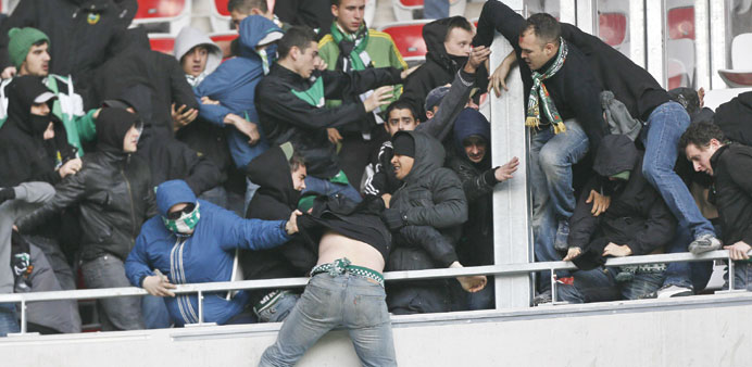 A supporter hangs on a balcony as supporters fight before the begining of the Ligue 1 match between Nice and Saint-Etienne on Sunday in Nice. (AFP)