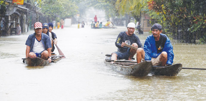 Residents ride on boats along a flooded road in Butuan city in the southern Philippine island of Mindanao yesterday.