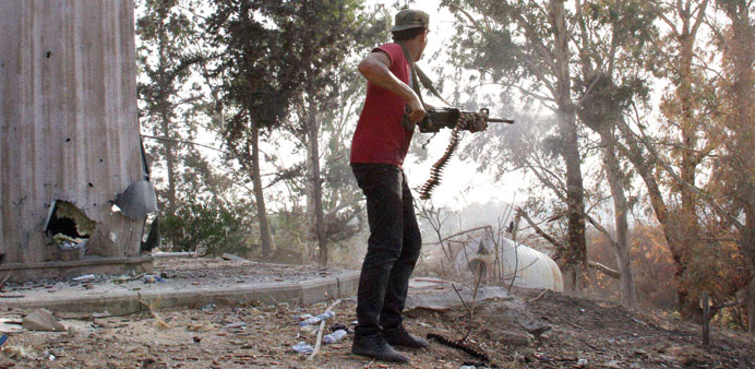 A man fires a weapon during fighting between rival militias around Tripoli international airport on Sunday.