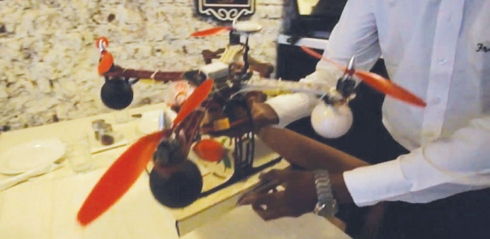 In this image taken from a promotional video by Francescou2019s Pizzeria, a drone aircraft held by a waiter prepares to fly a pizza to a customer in Mumba