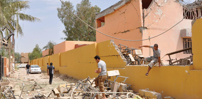 Residents inspect damage yesterday following shelling by government forces in an area of Fallujah held by anti-government fighters.