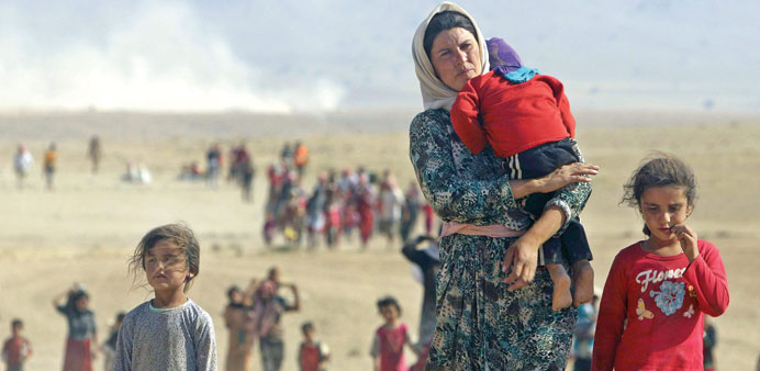 Yazidis who fled from Sinjar town walk towards the Syrian border on Monday.