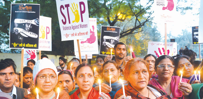 Demonstrators hold candles in honour of Nirbhaya who was gang-raped and murdered, as they mark the first anniversary of her death in New Delhi yesterd