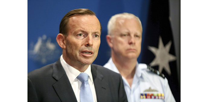 Australian Prime Minister Tony Abbott addresses a press conference in Darwin as Air Chief Marshal Mark Binski looks on.   