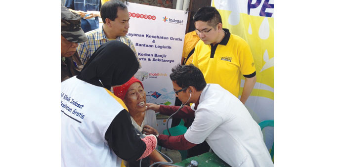 Helping flood victims at an Indosat mobile clinic.