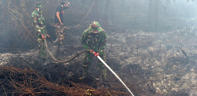 Indonesian soldiers along with firemen put out a fire on a farm land in Kampar, Riau Province yesterday.