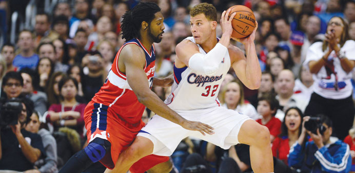 Blake Griffin of the Los Angeles Lakers looks to pass under pressure from Nene of the Washington Wizards during their NBA game in Los Angeles on Satur