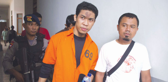 One of several terror suspects Separiano (centre) is escorted by police before his first trial in Jakarta yesterday for alleged involvement in a plot 
