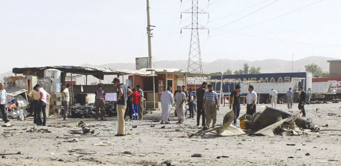 Residents gather at the site of the suicide bomb attack in Tuz Khurmatu yesterday.