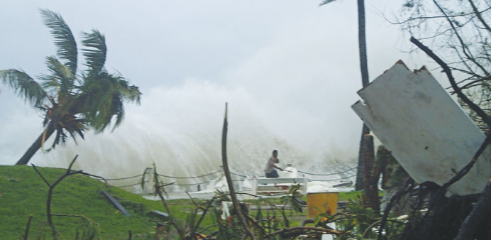 This handout photo taken on Saturday and received yesterday by CARE Australia shows a man fleeing high waves caused by Cyclone Pam, crashing along the