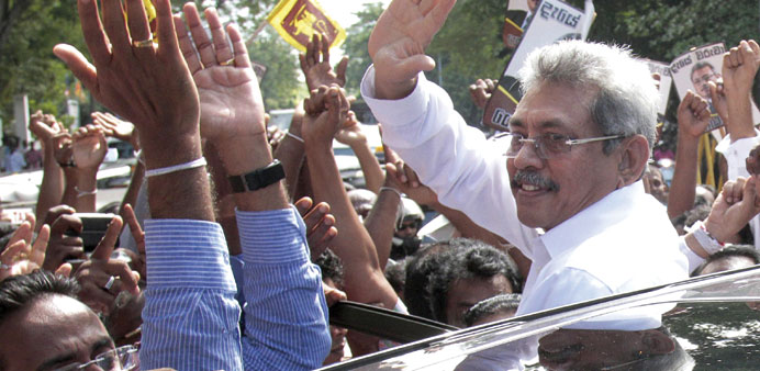 Former defence ministry chief Gotabhaya Rajapakse waves to supporters.