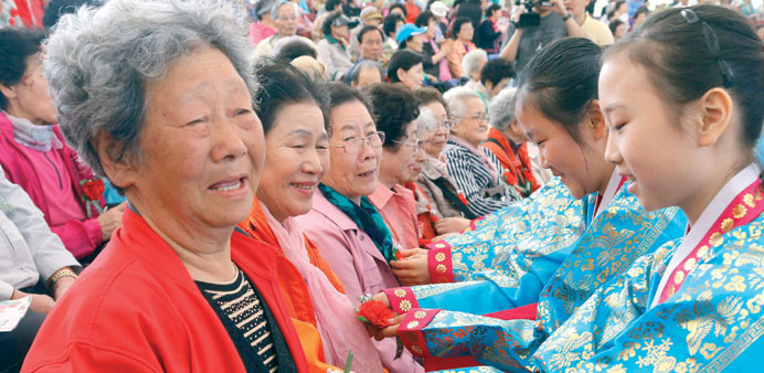 Children pin carnations on seniors at an event in Songpa-gu, southeastern Seoul, yesterday on the occasion of Parentsu2019 Day.