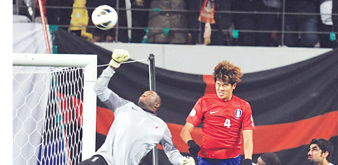 Qataru2019s goalkeeper Qasem Burhan (L) makes a save against South Korea during their World Cup Asian qualifier in Seoul yesterday. South Korea won the ma