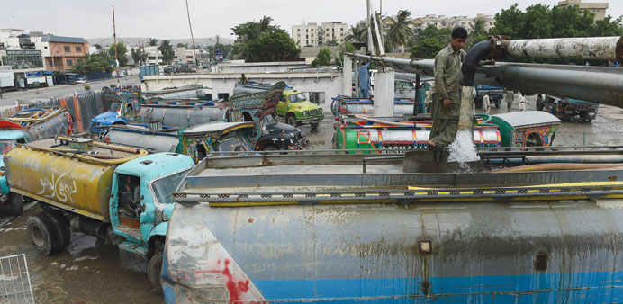 Employees fill water tankers at a government hydrant to provide residential areas in Karachi. 