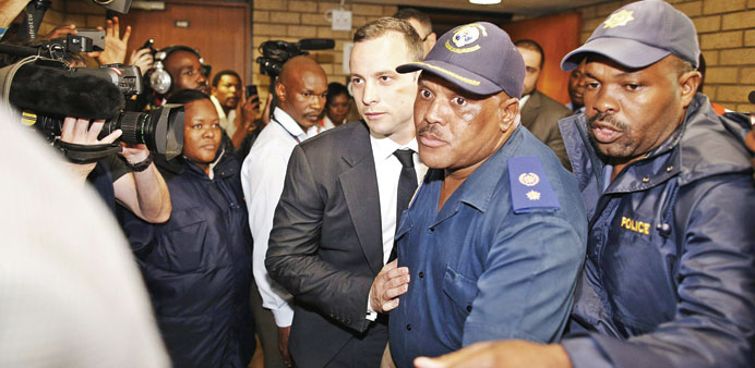 South African Paralympian star Oscar Pistorius leaves the court under police escort after the first day of his trial in Pretoria. 