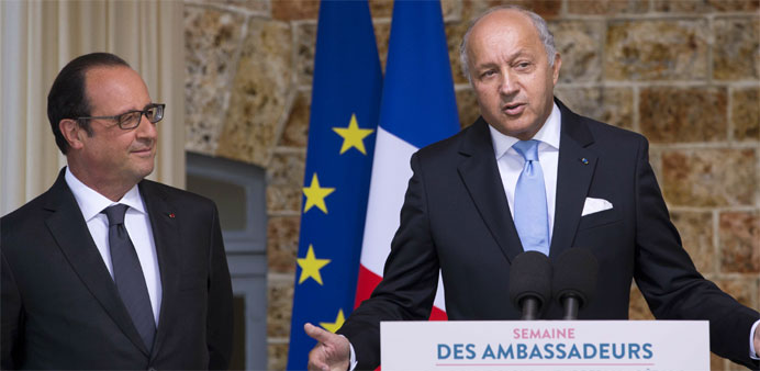 French Foreign Affairs Minister Laurent Fabius (R) delivers a speech next to French President FranCois Hollande (L) 