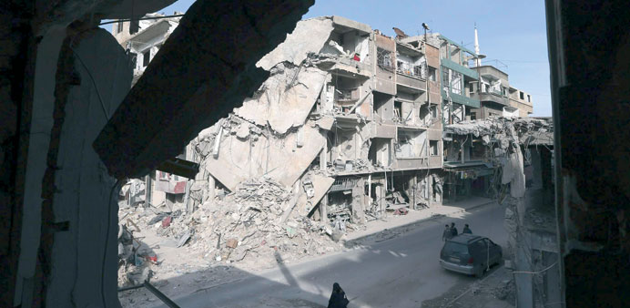 Buildings destroyed in attacks by the Syrian air force are seen in the Duma neighbourhood of Damascus yesterday.