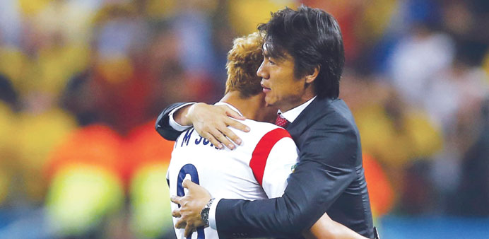 South Koreau2019s Son Heung-min (left) is consoled by coach Hong Myung-bo after their loss to Belgium in Sao Paulo on Thursday. (Reuters)
