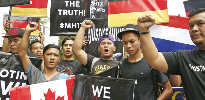 Protesters chant slogans demanding justice for the victims of Malaysia Airlines Flight MH17 as they follow the lead of organisers of a rally held by U
