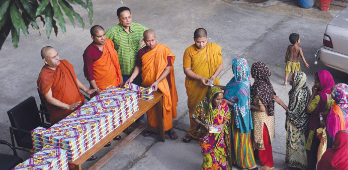 Buddhist monks giving out Iftar meals to Bangladeshi Muslims in the main shrine of Dhammarajika Monastery in Dhaka. 