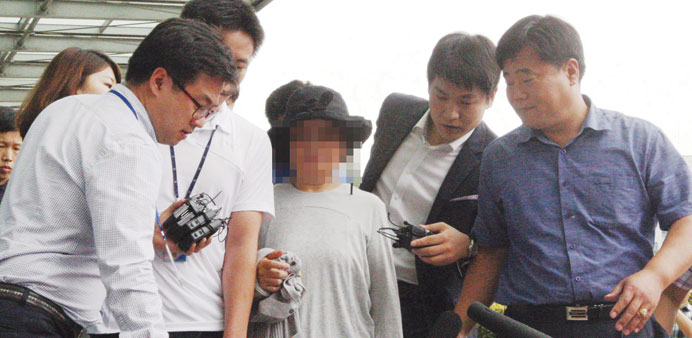 Kwon Yun-ja (centre) being arrested at an undisclosed location in South Korea on embezzlement charges. (Face of detainee pixelated under South Korean 