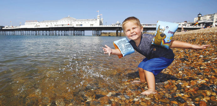 Two-year-old Reggie Jackson plays in the sea during the hot summer weather by Brighton pier in southern England yesterday.