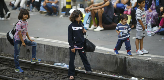 Migrants wait  for a train at the Keleti train station in Budapest