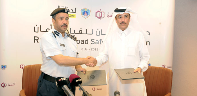 Brigadier al-Kharji and al-Kuwari shake hands after announcing the road safety campaign.