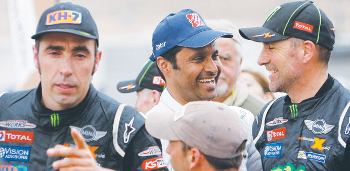 Nani Roma (left) of Spain celebrates beside Stephane Peterhansel (right) of France and Nasser al-Attiyah (centre) of Qatar after winning the Dakar Ral