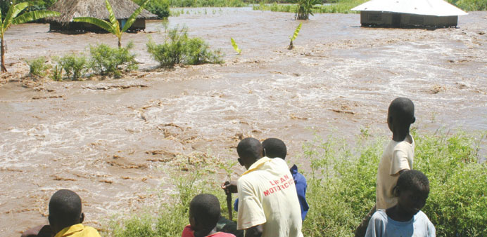 Residents of Kano plains look at one of the homes submerged by flood waters after the Nyando river burst its banks last week.