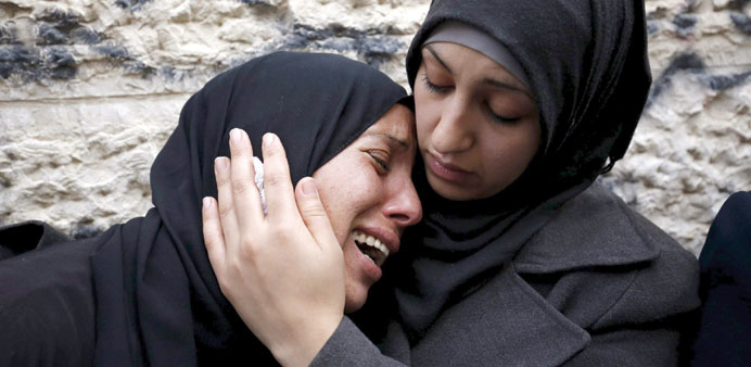 A relative of Palestinian Ahmed al-Ayesh, who was killed by Israeli troops yesterday, is comforted as she mourns during his funeral in Qalandiya refug