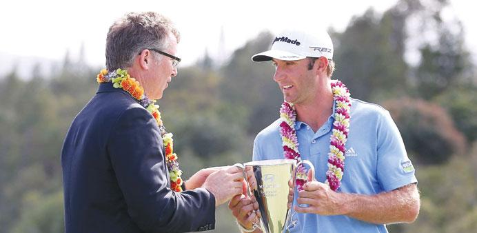 Dustin Johnson (R) is awarded the Hyundai Tournament of Champions Cup by Vice President of Marketing for Hyundai Motor America, Steve Shannon followin