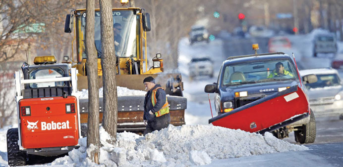 City workers use a variety of ploughs to remove snow from sidewalks in south Minneapolis yesterday.