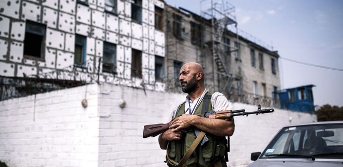A rebel gunman patrols yesterday in a yard of a high-security prison after shelling in Donetsk. More than 100 inmates broke out when shells rained dow