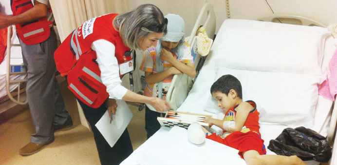 QRC worker attending on a wounded Syrian child.