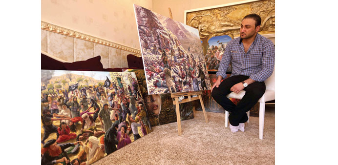 Ammar Salim poses near some of his art pieces at his workshop in Dohuk.